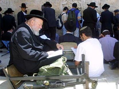 Un hombre lee un libro sagrado ante el Muro de las Lamentaciones, ayer durante la conmemoración de la destrucción del primer y segundo templo de Jerusalén.