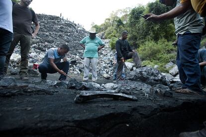 Varios campesinos inspeccionan la zona donde, seg&uacute;n las autoridades, fueron calcinados los cuerpos de los 43 normalistas desaparecidos en Iguala el 26 de septiembre.