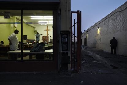 O pastor Emmanuel Okoli, à esquerda, faz um sermão e um ato religioso para pessoas sem lar na missão de Outreach, em Skid Row.