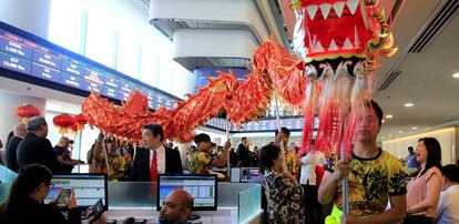 Operadores observan el desfile de un dragón tradicional en la Bolsa de Manila (Filipinas)