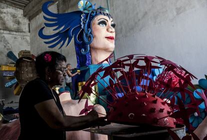 Una mujer prepara una de las carrozas que desfilarán en el carnaval de Barranquilla, el segundo más importante después de Río de Janeiro.