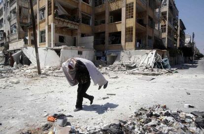 Un soldado sirio lleva el cuerpo de un compañero de combate durante los enfrentamientos en Aleppo. Imagen del 16 de agosto 2012.