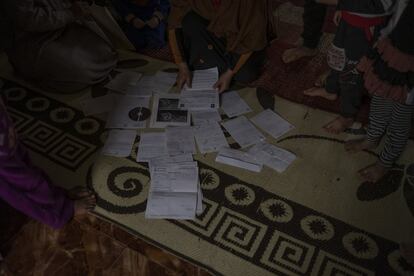 Tahar Alí y Samira Abdala muestran su documentación médica sobre el suelo de su salón. En Trípoli, la infancia no recibe la atención sanitaria suficiente.