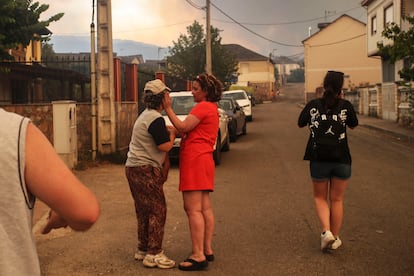 Varios vecinos conversan en las proximidades del incendio forestal que afecta al Parque de Las Médulas, el domingo.