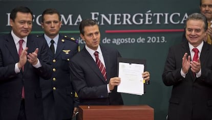 President Enrique Peña Nieto (c), next to Energy Secretary Pedro Joaquín Coldwell (r) and Mexican Interior Minister Miguel Osorio Chong (l), shows the reform bill on Monday.
