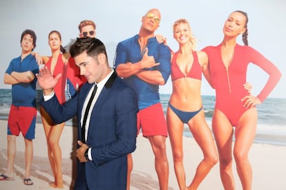 Ejercicio de agudeza visual. ¿Qué hace Zac Efron (29 años, EEUU) en esta foto de la presentación de 'Los vigilantes de la playa' en Nueva York? Está a punto de bailar un vals. Negativo. Se pega la corbata a la camisa. Error. Saluda a sus seguidores. Qué no. Lo que hace es taparse a él mismo, pero en la imagen de detrás. Por qué. Esa es la gran incógnita.