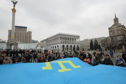 Un grupo de gente sostiene una bandera gigante de los pueblos tártaros de Crimea durante el aniversario de la anexión de Crimea por Rusia, el 25 de febrero de 2015 en Kiev (Ucrania).