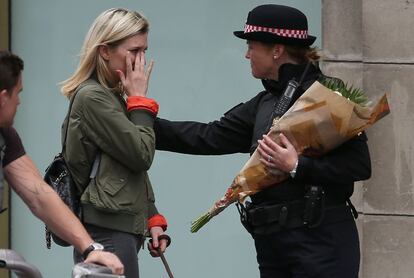 Una mujer llora mientras en consolada por un miembro de la policía cerca del London Bridge.