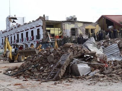 Bombeiros olham o que sobrou de um pr&eacute;dio municipal em Juchitan.