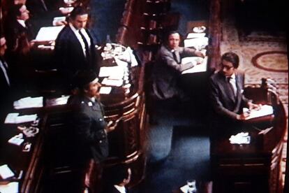 En esta imagen, capturada de la emisión televisiva, Tejero, pistola en mano, se dirige a los diputados desde la tribuna, mientras Landelino Lavilla, presidente del Congreso (de pie), mira atónito.