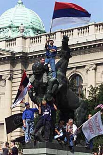 Manifestantes ondean una bandera serbia frente al Parlamento de Belgrado tras la insurrección contra Milosevic.