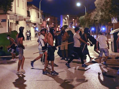 Varios jóvenes con palos, botellas y piedras, este domingo momentos antes de los enfrentamientos con la policía.