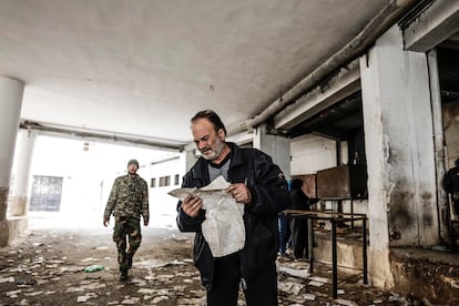 Un hombre revisa los ficheros en busca de información de un familiar en el patio de la prisión de Saidnaya.