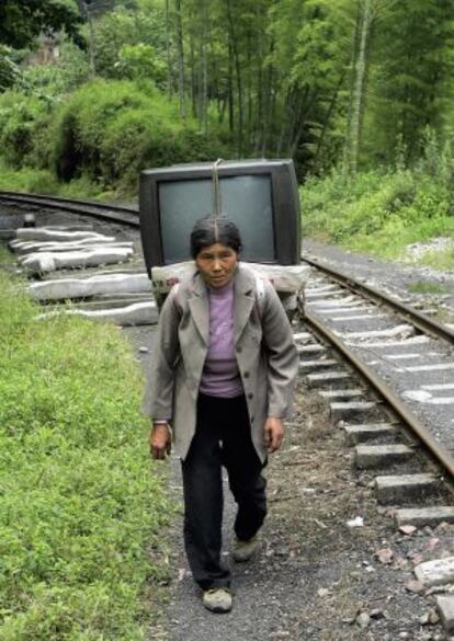 Una mujer transporta una televisión en Sichuan.