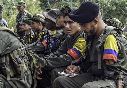 TO GO WITH AFP STORY by Hector Velasco
A Revolutionary Armed Forces of Colombia (FARC) guerrilla takes notes during a "class" on the peace process between the Colombian government and their force, at a camp in the Colombian mountains on February 18, 2016. They still wear green combat fatigues and carry rifles and machetes, but now FARC rebel troops are sitting down in the jungle to receive "classes" on how life will be when they lay down their arms, if their leaders sign a peace deal in March as hoped.  AFP PHOTO / LUIS ACOSTA