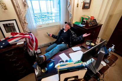 Un seguidor de Donald Trump, identificado como Richard Barnett, se sienta en el escritorio de la presidenta de la Cámara Baja, Nancy Pelosi, luego de irrumpir en el Capitolio.