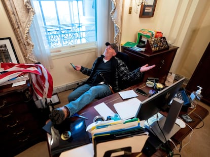 Un seguidor de Donald Trump, identificado como Richard Barnett, se sienta en el escritorio de la presidenta de la Cámara Baja, Nancy Pelosi, luego de irrumpir en el Capitolio.