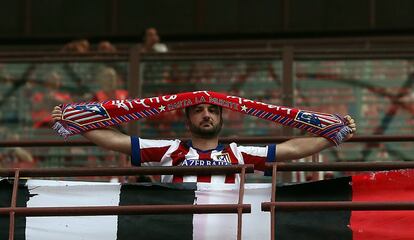 Simpatizante del Atlético de Madrid muestra la bandera de su equipo en la grada.