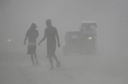 Os moradores caminham através de uma nuvem de cinzas enquanto o vulcão Taal continua atirando cinzas na segunda-feira, 13 de janeiro, em Lemery, província de Batangas. O vulcão, que entrou em erupção 33 vezes desde 1572, causou cerca de 1.300 mortes em uma erupção em 1911 e 200 em 1965.