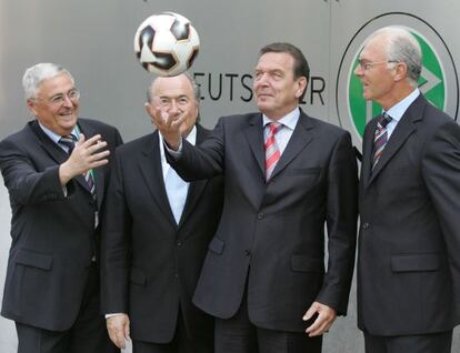 Gerhard Schröder juguetea con un balón de fútbol ante la mirada de Theo Zwanziger (i), Joseph Blatter (2i), y Franz Beckenbauer (d).