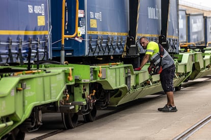 Un operario comprueba que los camiones montados en el tren han quedado bien fijados. Según los cálculos de Adif, la ruta está preparada para llevar unos 10.000 camiones al año, en cuatro trayectos de ida y vuelta semanales, con lo que el ahorro de emisiones llegaría a las 16.000 toneladas de CO₂.
