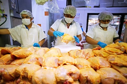 Trabajadores preparan pollo en un local en la Central de Abastos, en Ciudad de México.