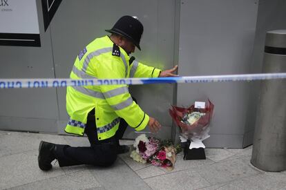 Un policía deja un ramo de flores en un altar improvisado en Londres.