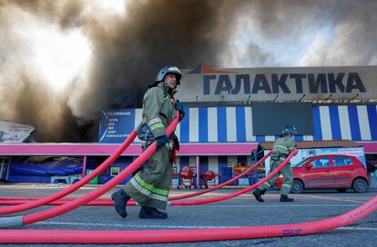 Bomberos trabajan para extinguir el fuego en el centro comercial Galaktika en Donetsk tras un bombardeo, este míercoles.