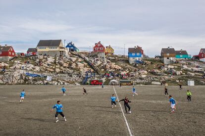 Partido de fútbol groenlandés con público en el gran campo de fútbol de Ilulissat, Groenlandia Occidental.