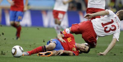 Sergio Busquetsy el Stephane Grichting, por los suelos tras un lance en el juego.