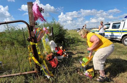 Una seguidora coloca una ramo de flores en un improvisado altar en la verja de la granja donde fue asesinado ayer.