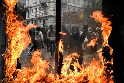 Un manifestante sostiene un cartel que dice "Sorprendido por el plástico quemado, pero no por nuestras pensiones robadas" durante la manifestación el Primero de Mayo en Lyon. 