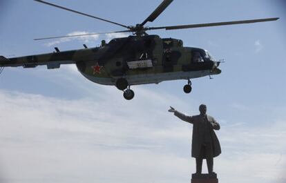 El helicóptero militar en el que viajaba Rosa Otunbáyeva, a punto de aterrizar en la plaza central de Osh junto a una estatua de Lenin.