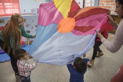 Las maestras preparan cada día actividades sensoriales para estimular el aprendizaje de Maxi y Lionel. La sala no ha sido beneficiosa para sus madres, sino también para ellos. En la imagen juegan al paracaídas. Los niños ríen cuando todos quedan debajo de la tela y las educadoras preguntan dónde están.