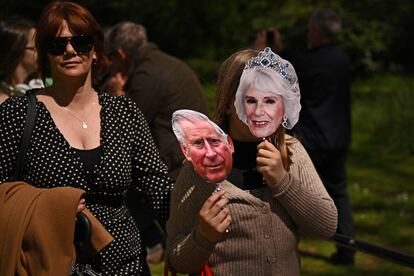 Fans con mascaras del rey Carlos III y su esposa Camila cerca del palacio de Buckingham, este viernes.