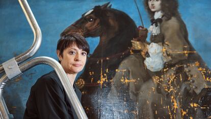 Eva Martínez posa junto al cuadro que está restaurando, 'Cristina de Suecia a caballo'.