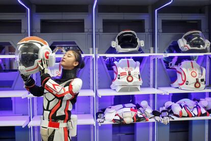 A inauguração do local ocorre quando a China tenta reduzir seu atraso em relação aos Estados Unidos e à Rússia na exploração espacial. O país espera mandar um homem à lua um dia. Na imagem, um membro da equipe demonstra como colocar o capacete do traje espacial.