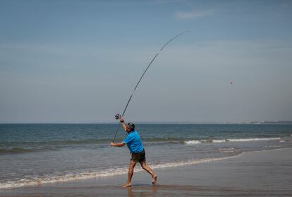 Un hombre pescando en la playa de Punta Umbría (Huelva) el 21 de mayo.