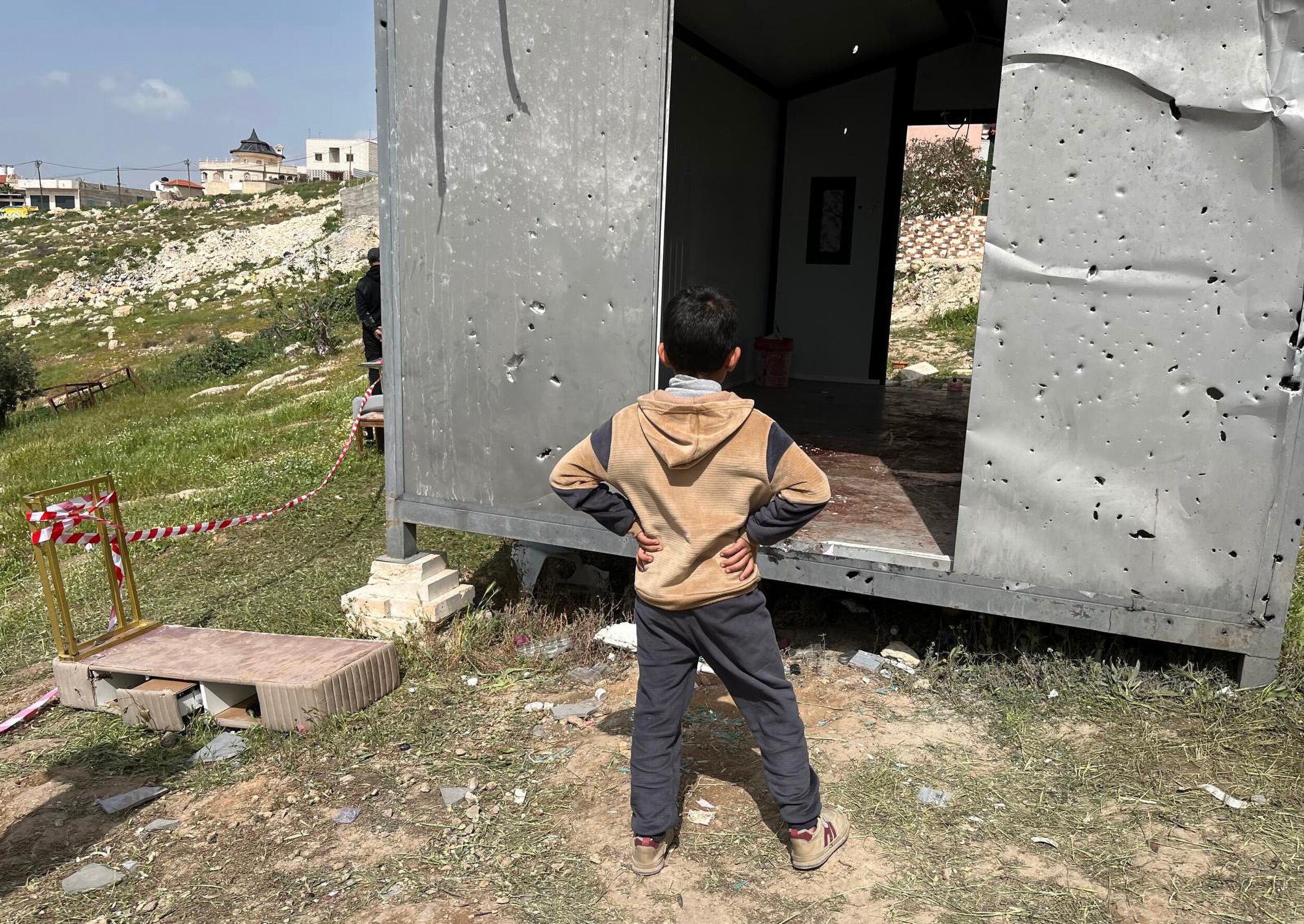 19/03/26 Un niño observa el salón de belleza junto al que cayó el proyectil, en Beit Awa (Cisjordania),. Foto: Antonio Pita