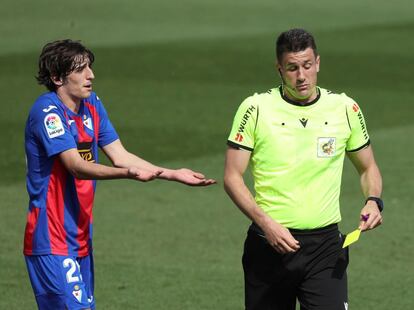 El jugador del Eibar Bryan Gil es amonestado por el árbitro Isidro Díaz de Mera por pisar a Lucas en la esquina del área.