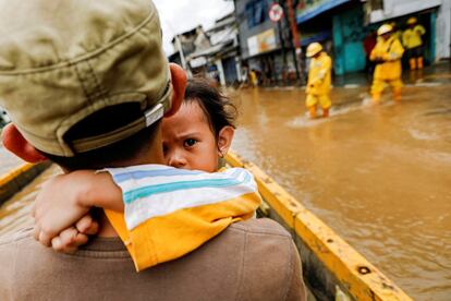 Más de 31.000 personas han sido evacuadas a refugios provisionales después de que sus viviendas sufrieran daños. En la imagen, un padre coge en brazos a su hija para cruzar las calles inundadas en Yakarta.