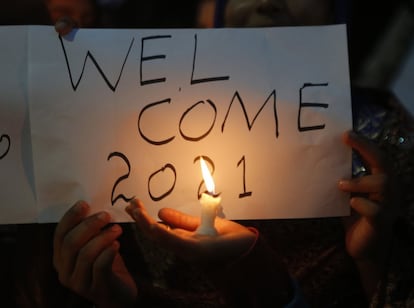 Menina com cartaz que diz "Bem-vindo 2021", em Lahore (Paquistão).