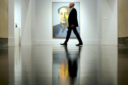 Un hombre pasa delante del cuadro <i>Mao</i> de Andy Warhol en la casa de subastas Christie&#39;s en Nueva York. El cuadro es uno de los que más repercusión está cobrando en la muestra newyorkina.