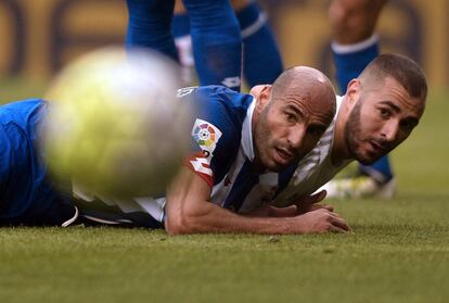 Manuel Pablo (i) del Deportivo y Benzema (d) del Real Madrid miran el balón.