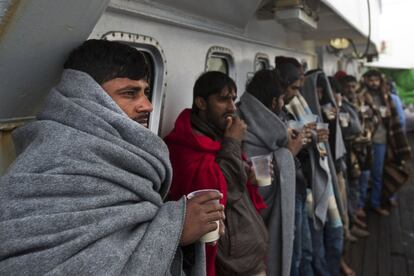 Un grupo de migrantes desayunan en el exterior del buque un día después de ser rescatados, el 7 de abril.