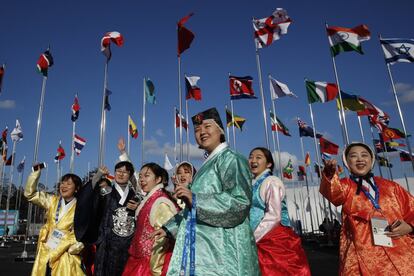 Un grupo de voluntarios, vestidos con trajes tradicionales, dan la bienvenida a los atletas a su llegada a la villa olímpica en Gangneung (Corea del Sur). 