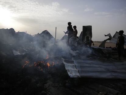 Palestinos observan la destrucción provocada por un ataque israelí, este lunes en un campo para desplazados de Rafah.