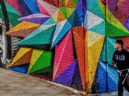 Un joven pasa junto a un grafiti en el barrio de Lavapiés.