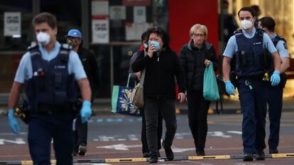 Agentes de la policía escoltan a varias personas en el exterior del centro comercial en Auckland, este viernes.