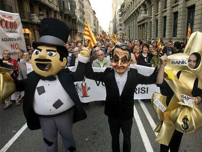 Un manifestante con una careta de Zapatero acompañado de dos muñecos símbolos del capitalismo, ayer en la Via Laietana.